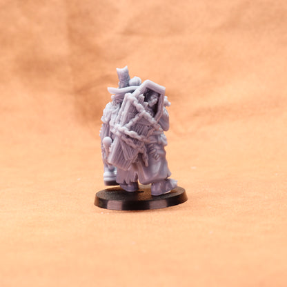 Gray miniature figure on a black base against a beige background