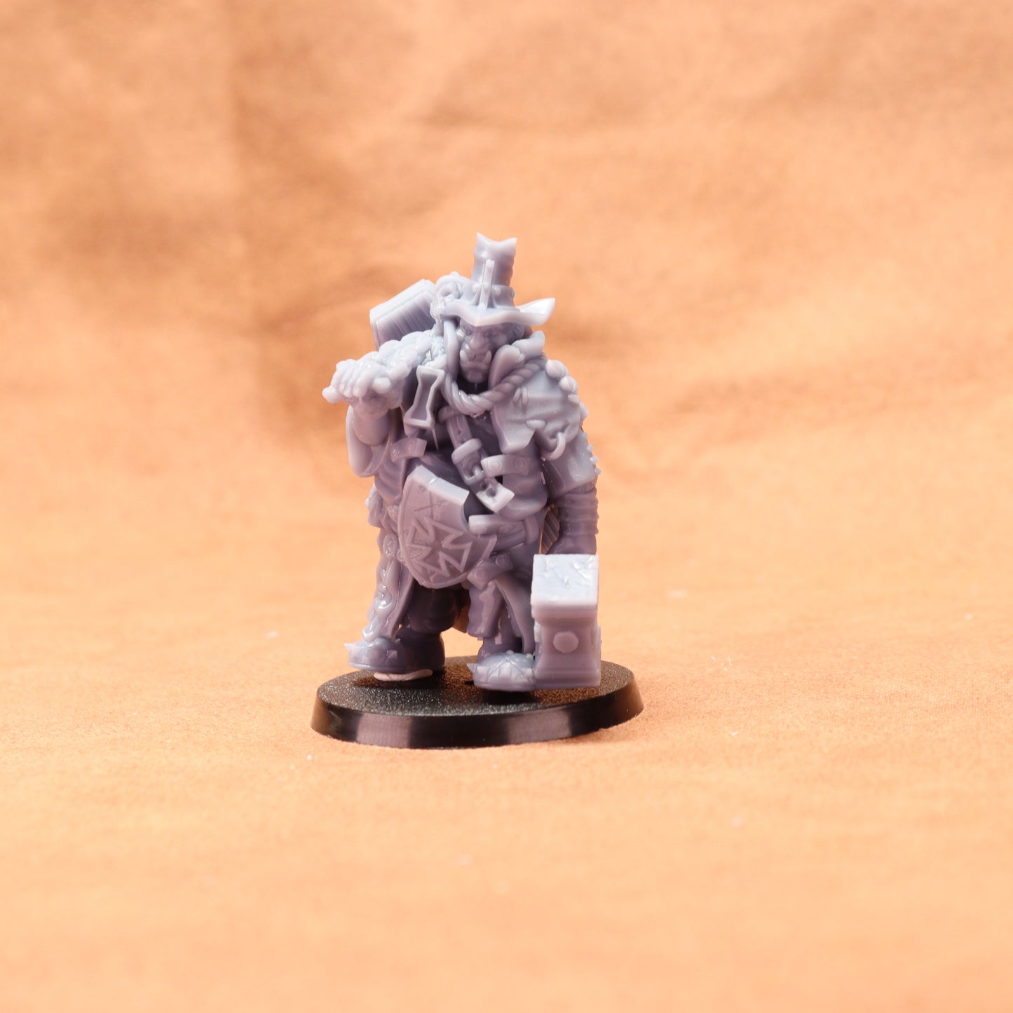 Gray miniature figure on a black base against an orange background