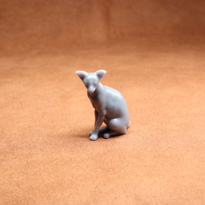 Gray ceramic dog figurine on a brown surface