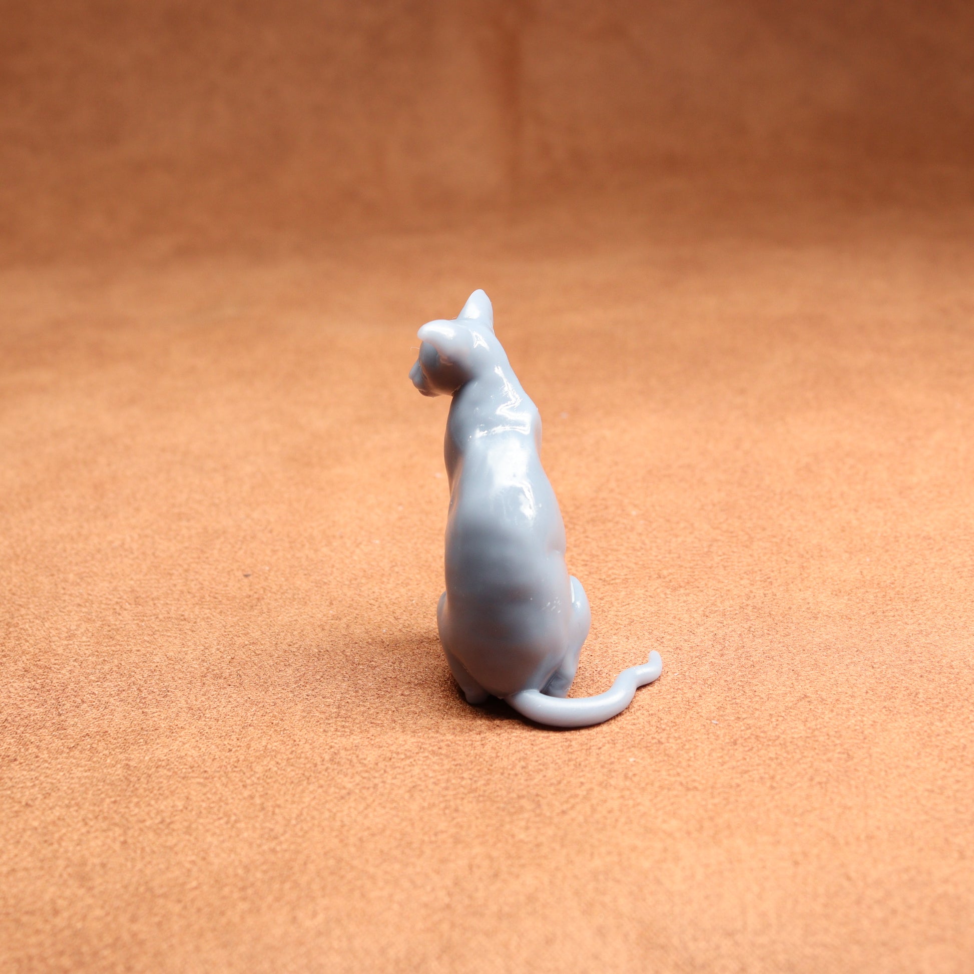 Small ceramic cat figurine on a brown surface
