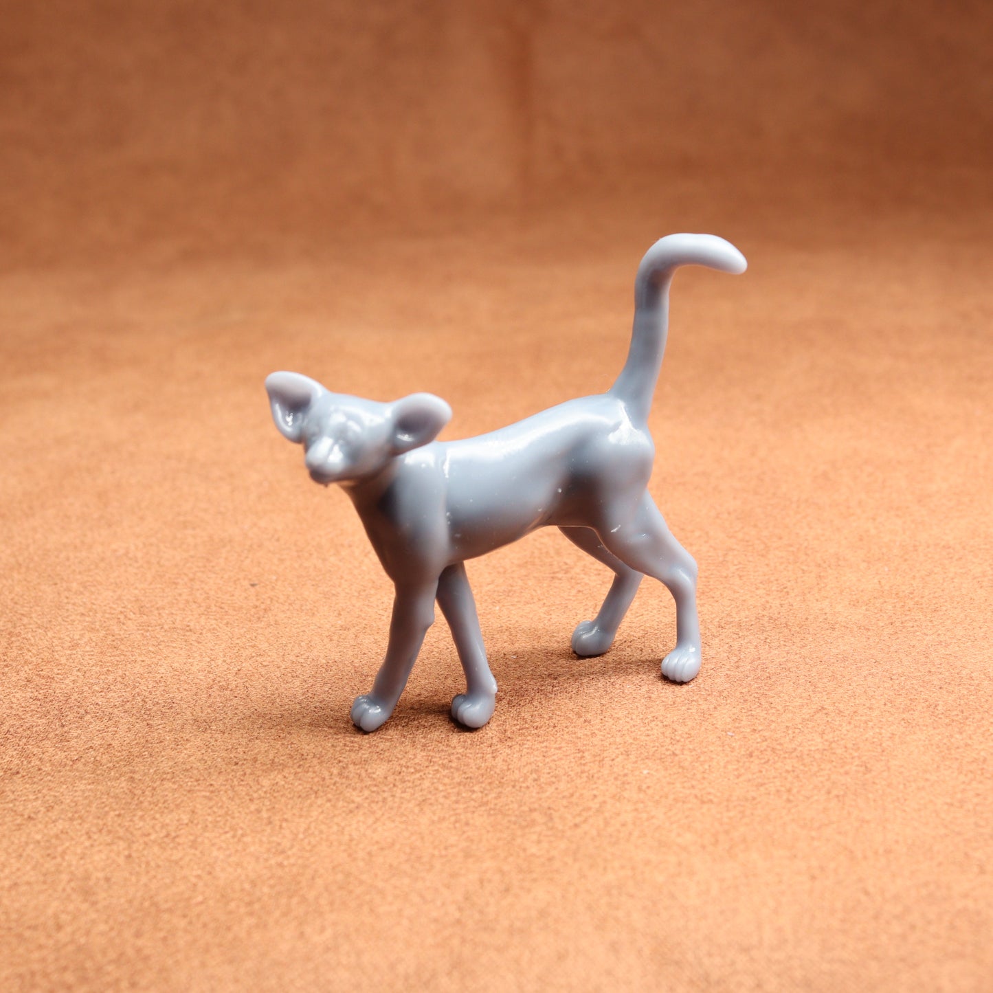 Gray cat figurine on a brown surface