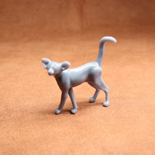 Gray cat figurine on a brown surface