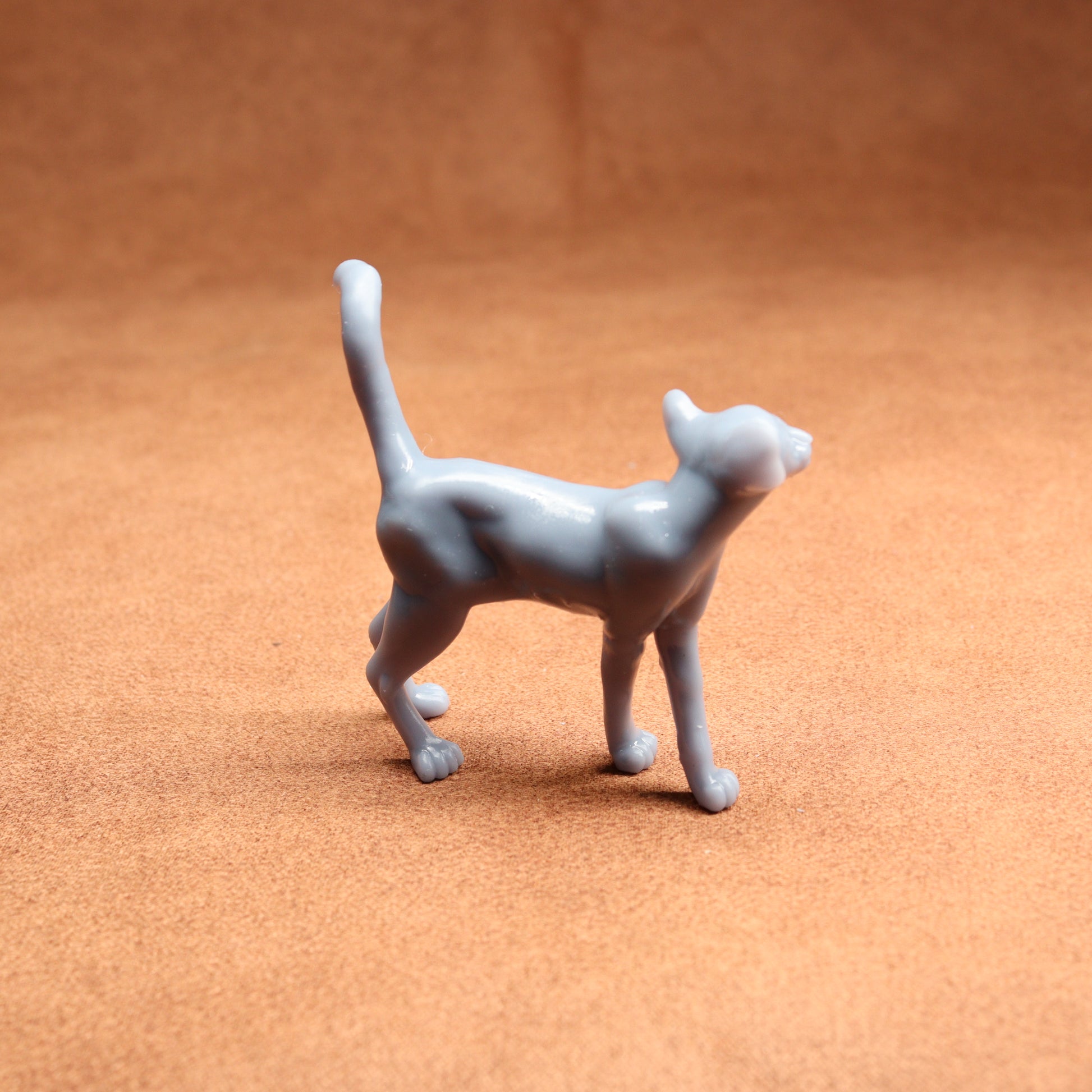 Gray cat figurine on a brown surface