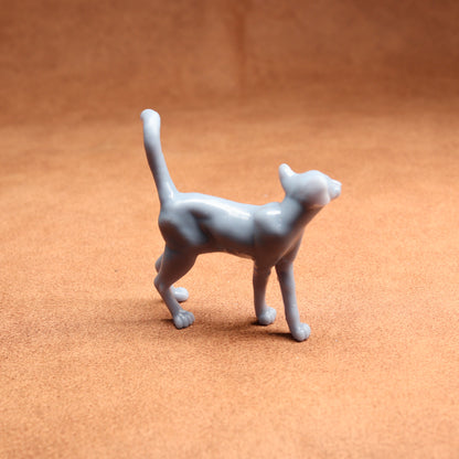 Gray cat figurine on a brown surface