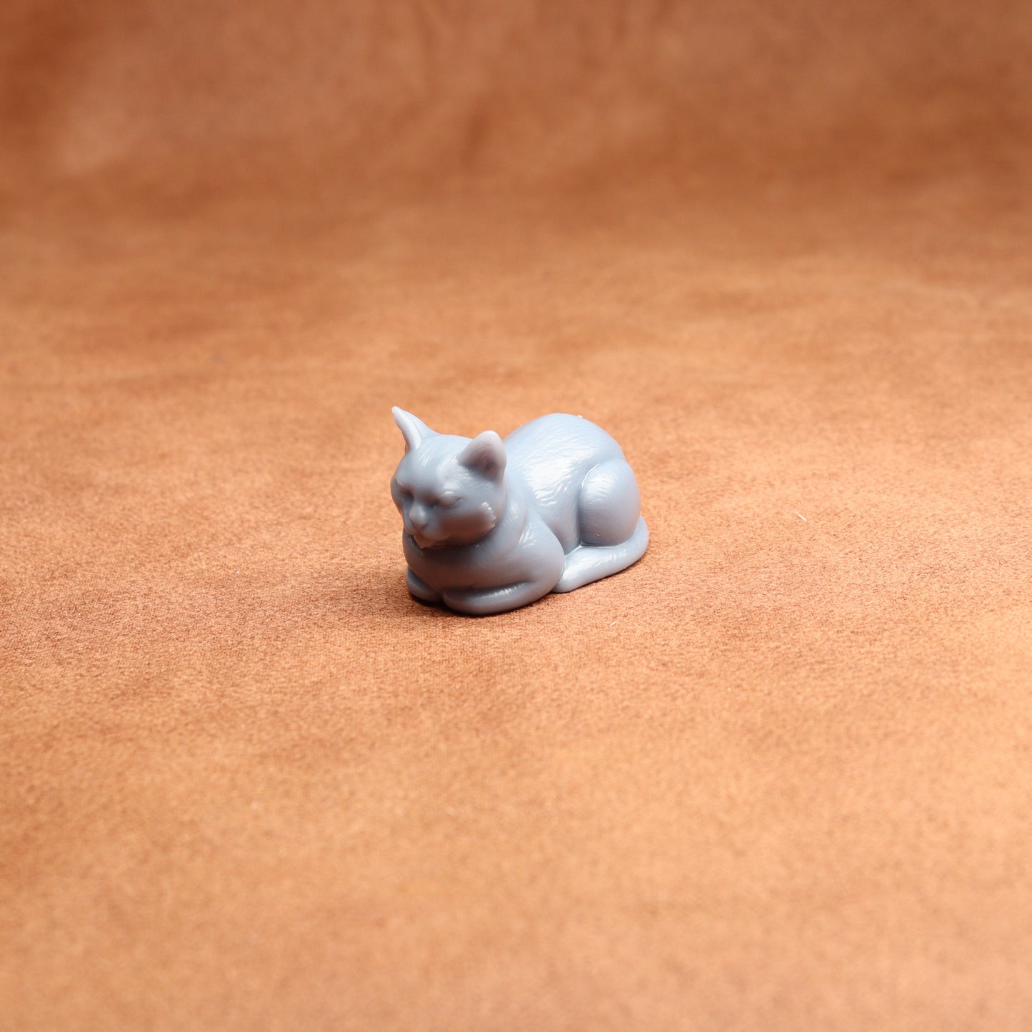resting resin cat miniature on a brown surface