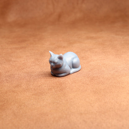 resting resin cat miniature on a brown surface