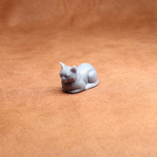 resting resin cat miniature on a brown surface