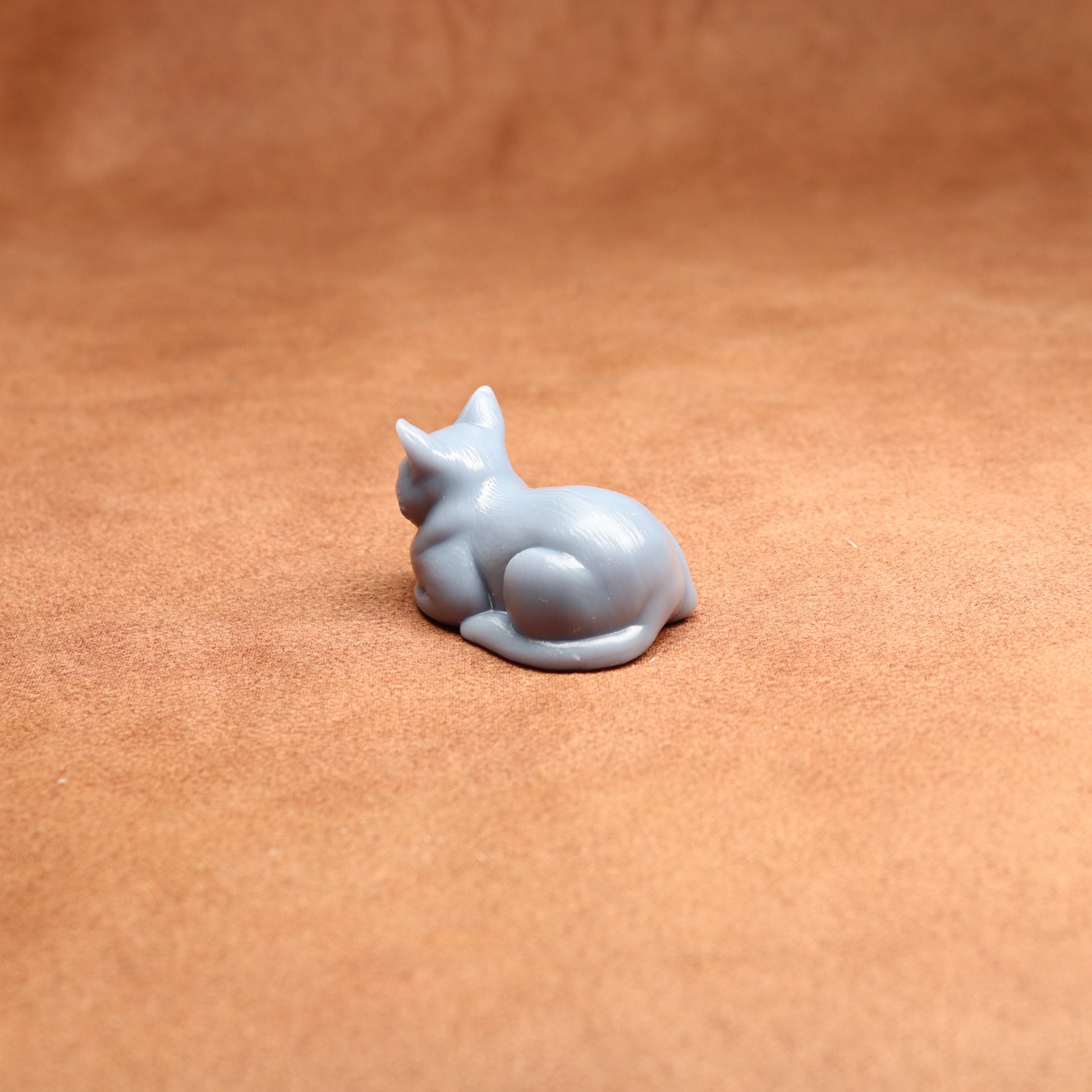resting resin cat miniature on a brown surface