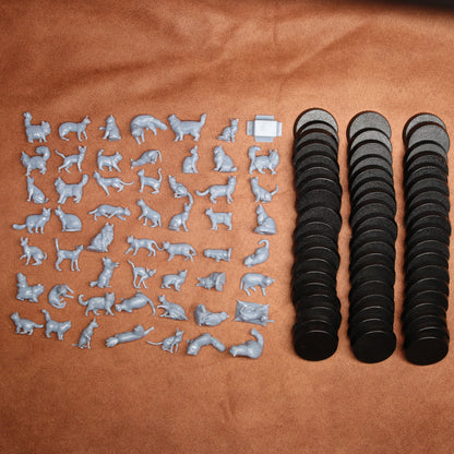 grey miniature resin cat figurines next to black round bases on a brown background.