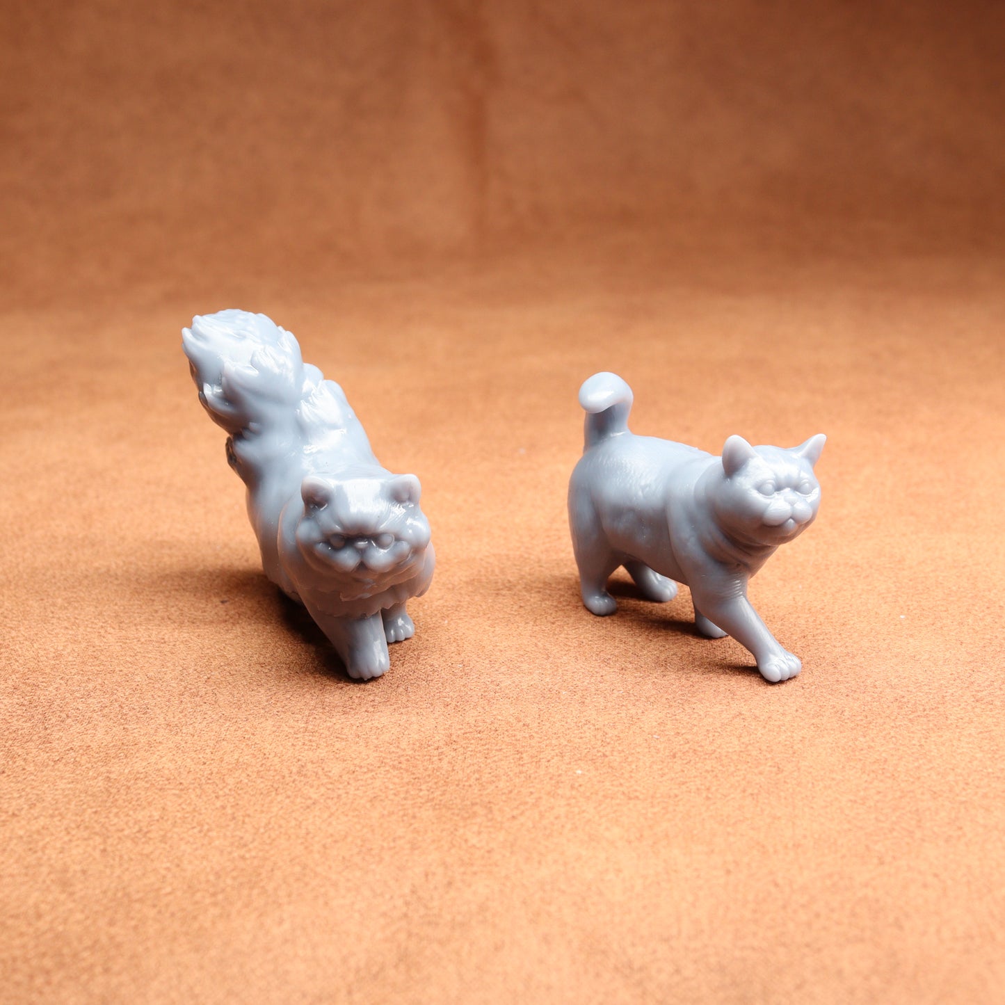 Two small white animal figurines on a brown surface