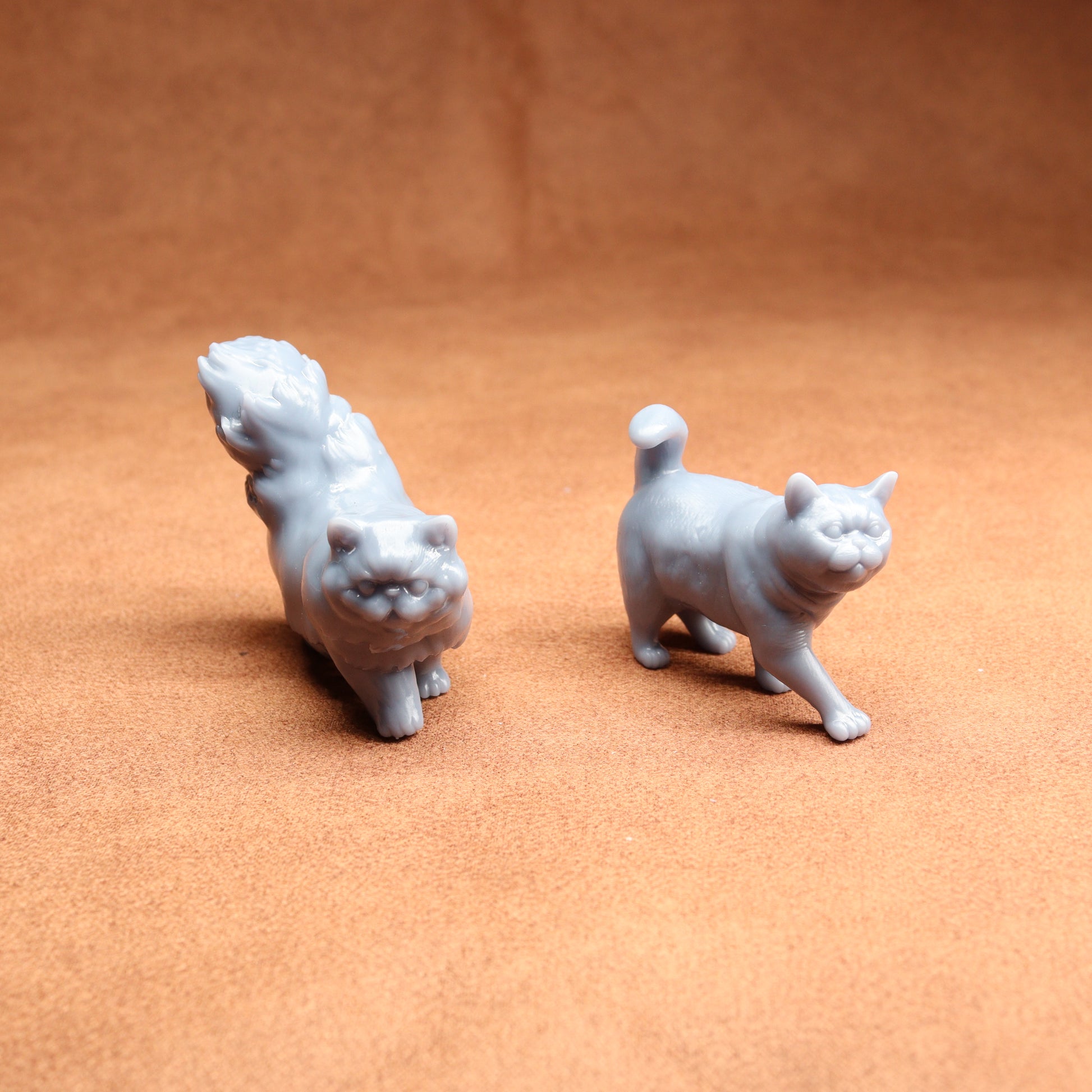Two small white animal figurines on a brown surface