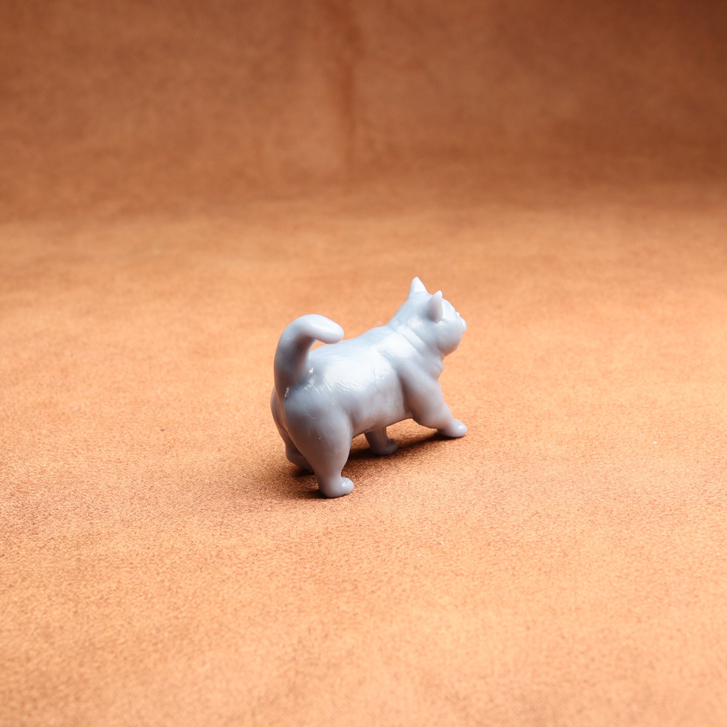 Small white dog figurine on a brown surface