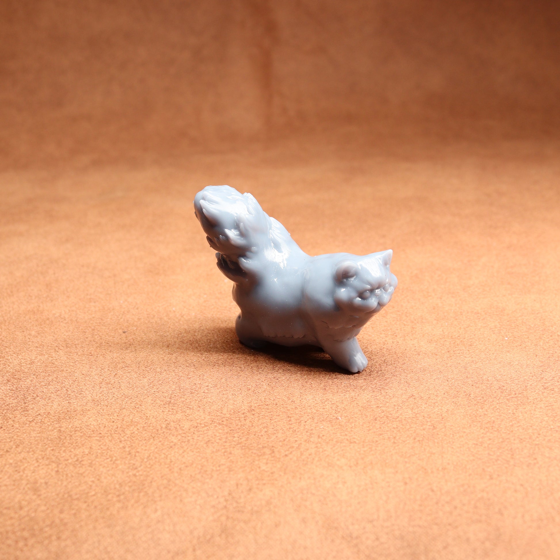 White ceramic cat figurine on a brown surface