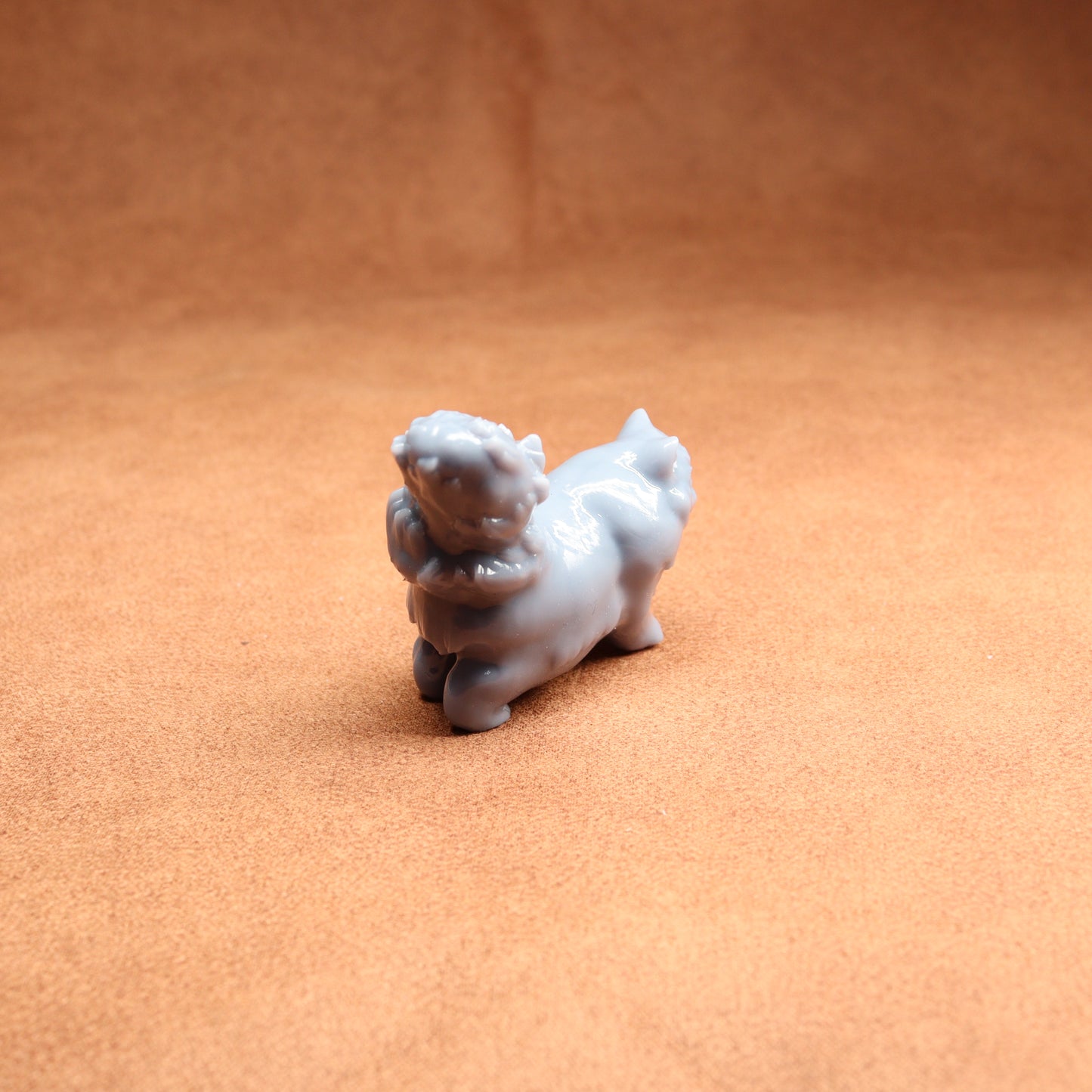 Small white figurine of a dog on a brown surface