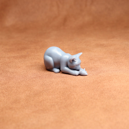 Gray cat figurine on a brown surface
