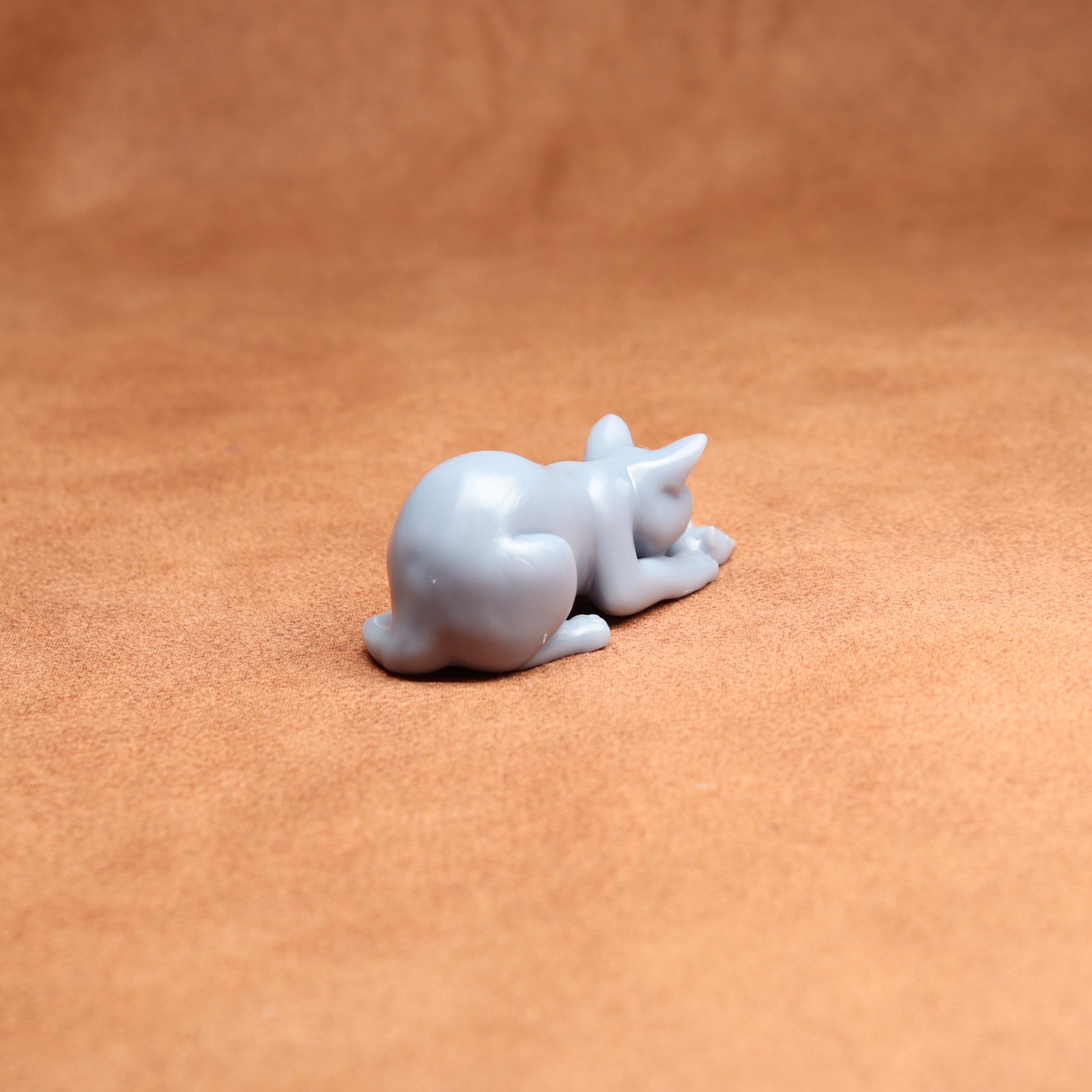 White resin cat figurine on a brown surface