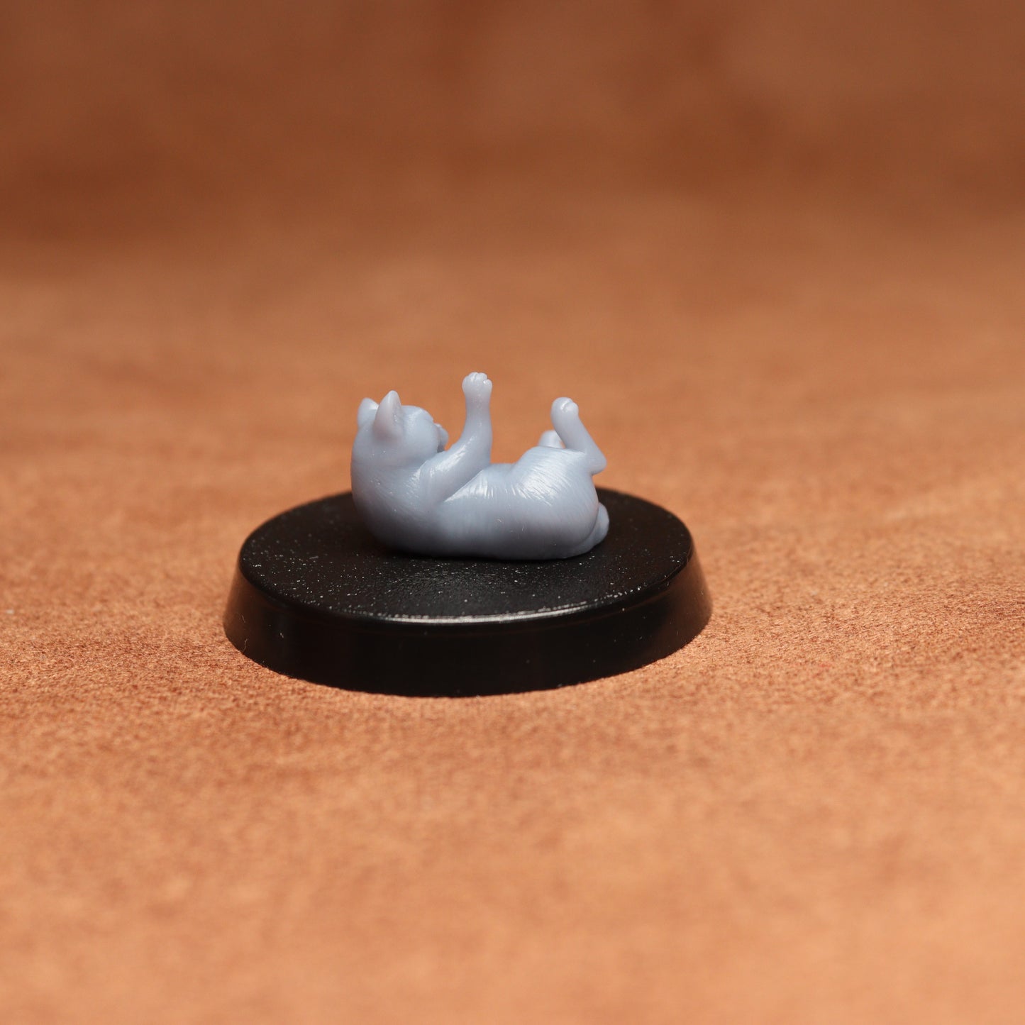 Small figurine on a black base against a brown background