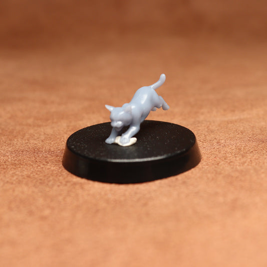 White figurine of a cat on a black round base against a brown background