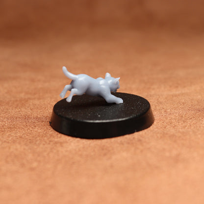 White figurine of a cat on a black round base against a brown background
