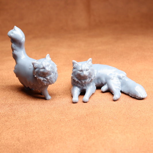 Two white ceramic cat figurines on a brown surface
