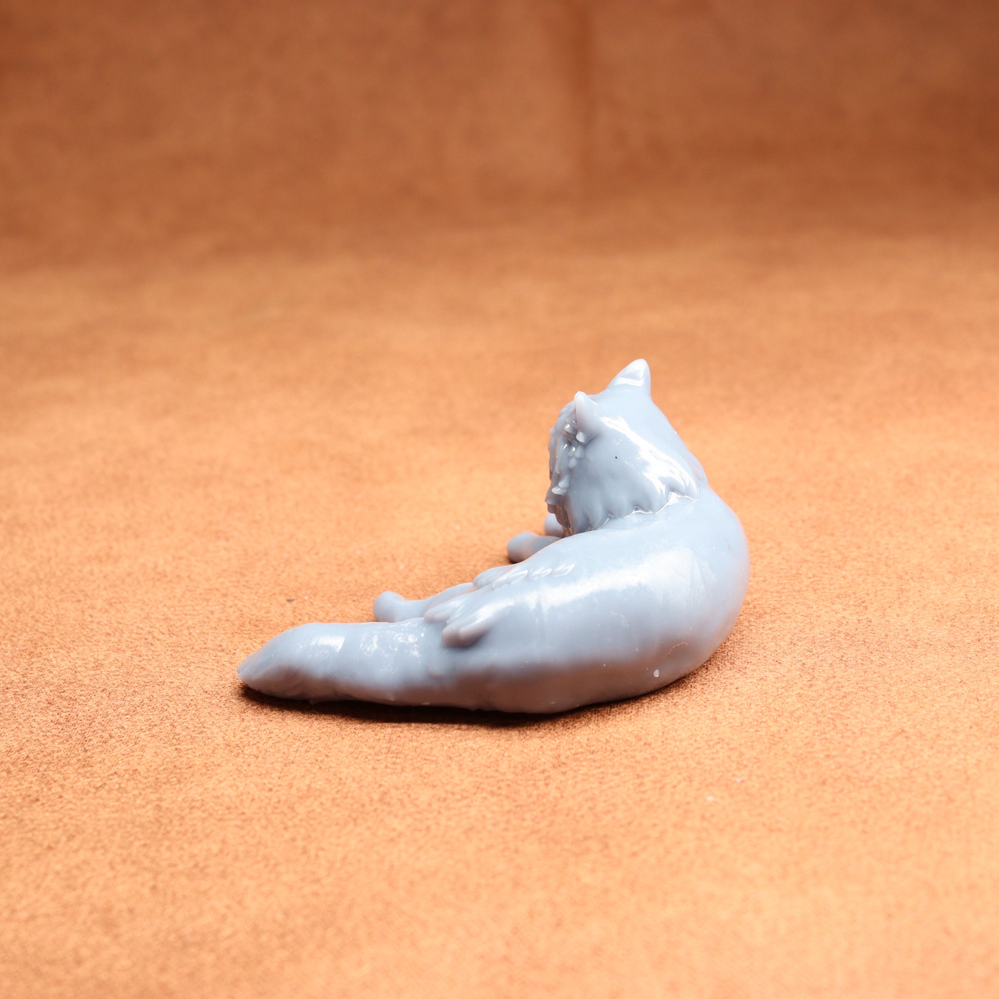 White ceramic cat figurine on a brown surface