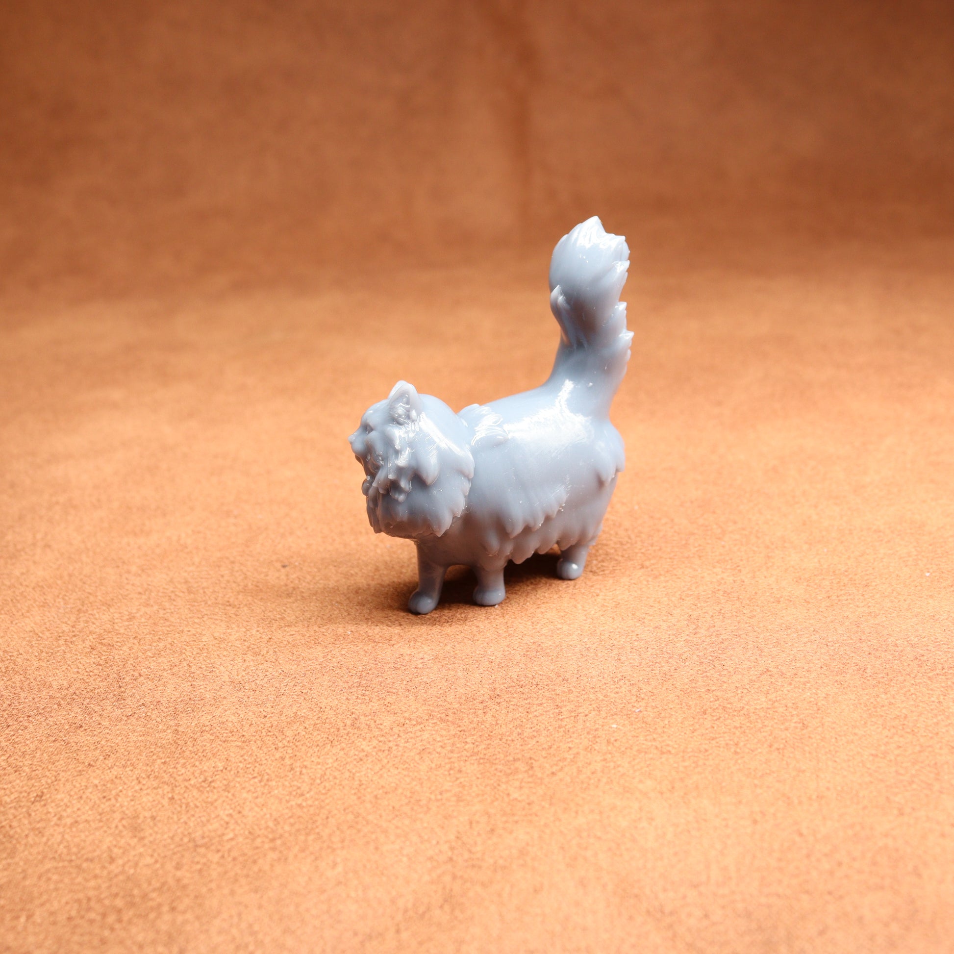 White ceramic cat figurine on a brown surface