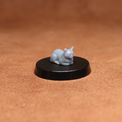 grey cat resin miniature on a black base on a brown background.