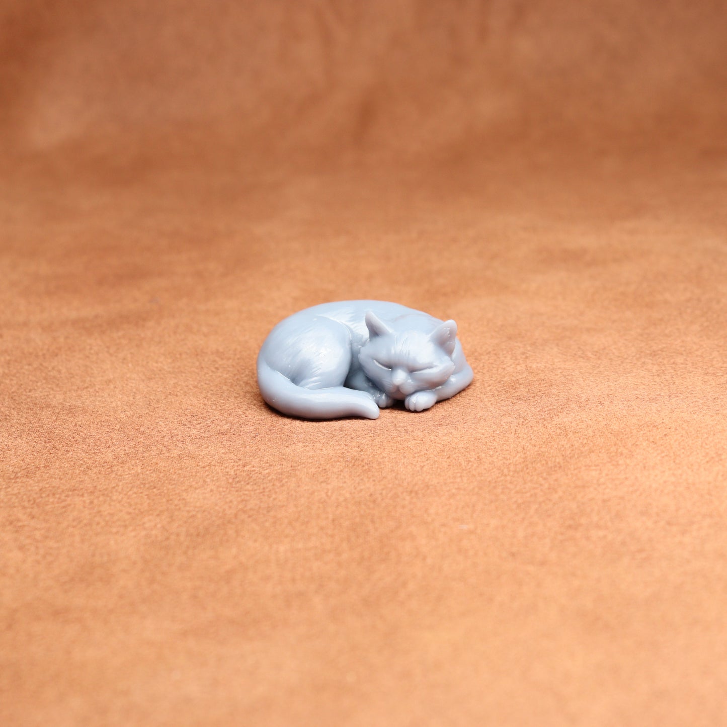 White cat figurine on a brown leather surface