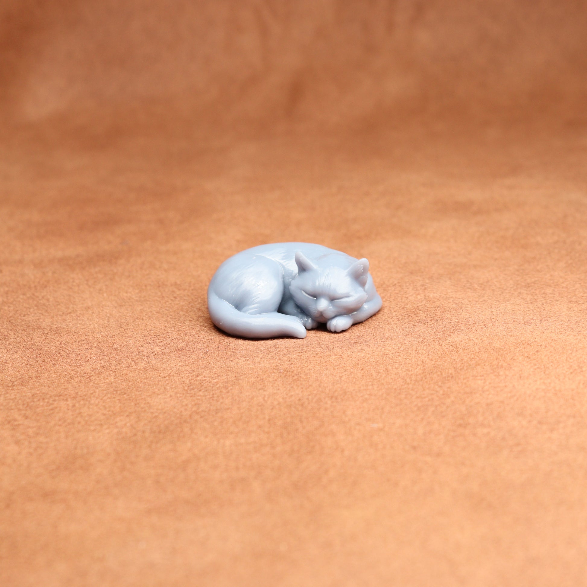 White cat figurine on a brown leather surface