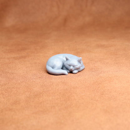 White cat figurine on a brown leather surface