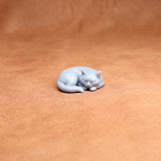 White cat figurine on a brown leather surface