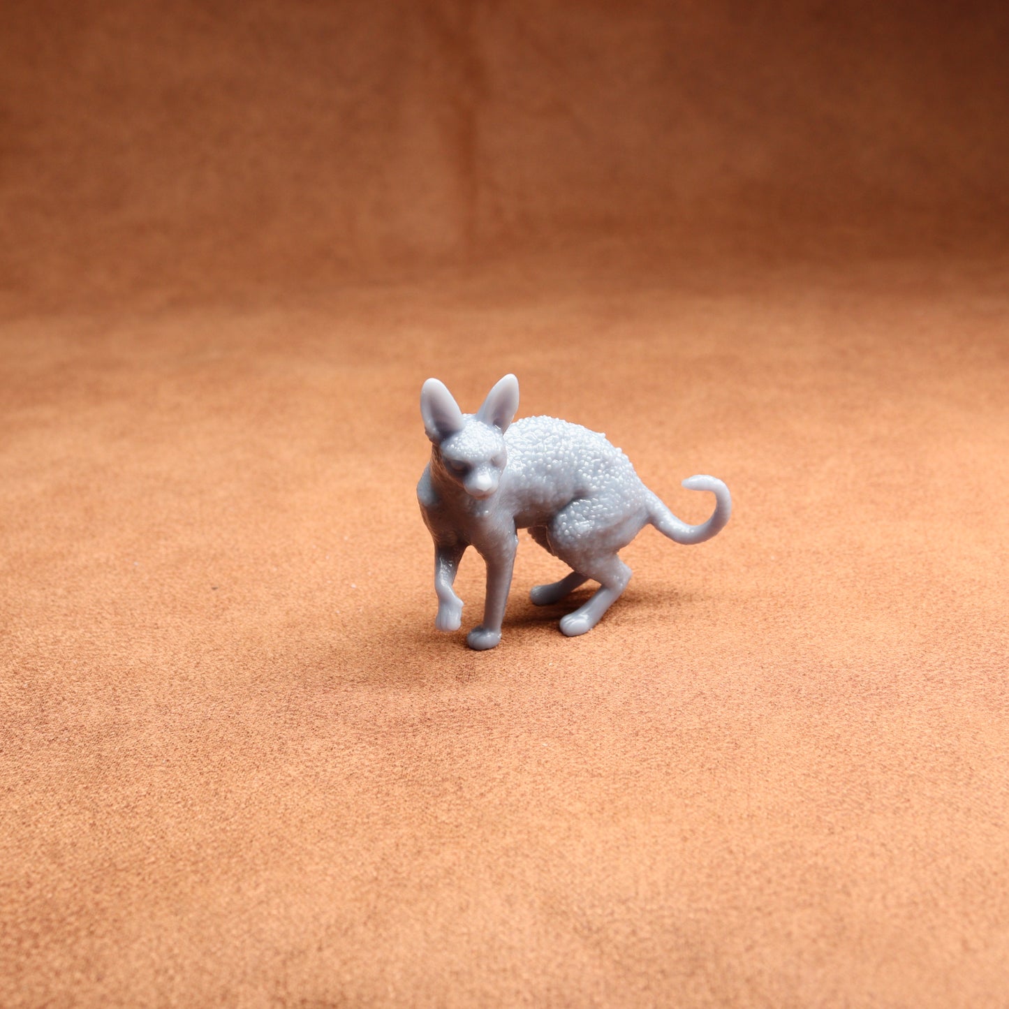 Gray 3D-printed dog figurine on a brown surface