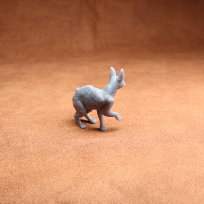 Small gray figurine of a kangaroo on a brown textured surface