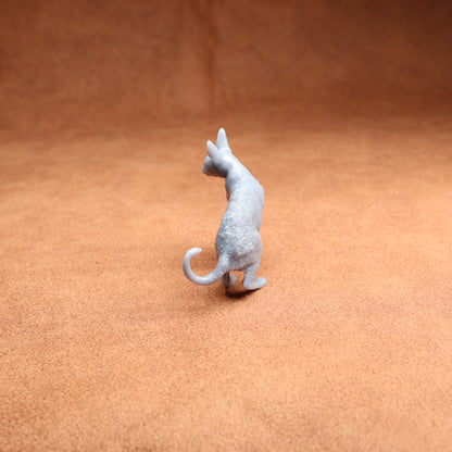 Small gray cat figurine on a brown surface
