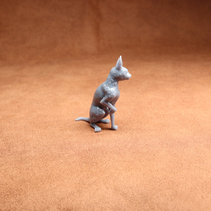 Gray cat figurine on a brown textured surface