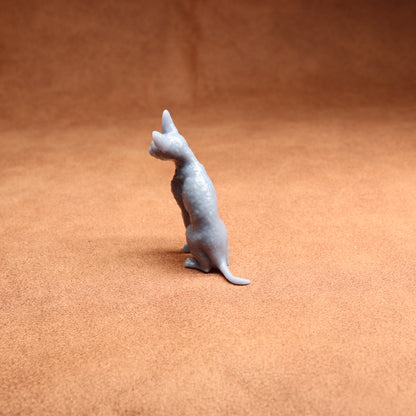 Small gray cat figurine on a brown surface