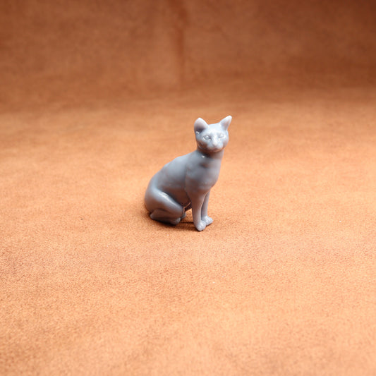 Gray cat figurine on a brown surface
