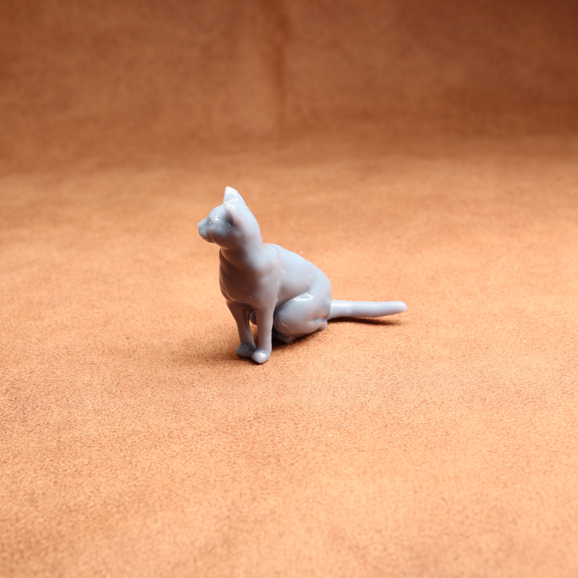 Cat figurine on a textured orange surface