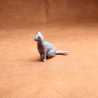 Cat figurine on a textured orange surface