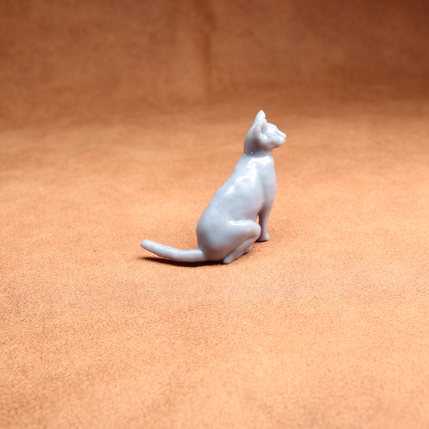 White ceramic cat figurine on a brown surface