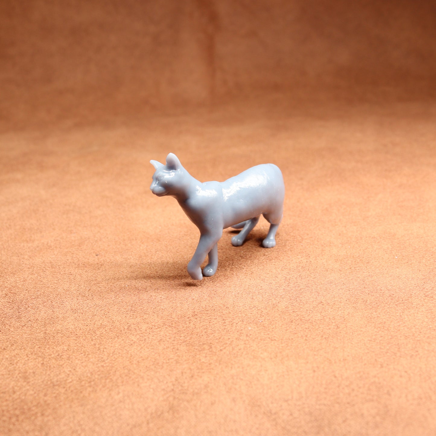 White ceramic cat figurine on a brown surface