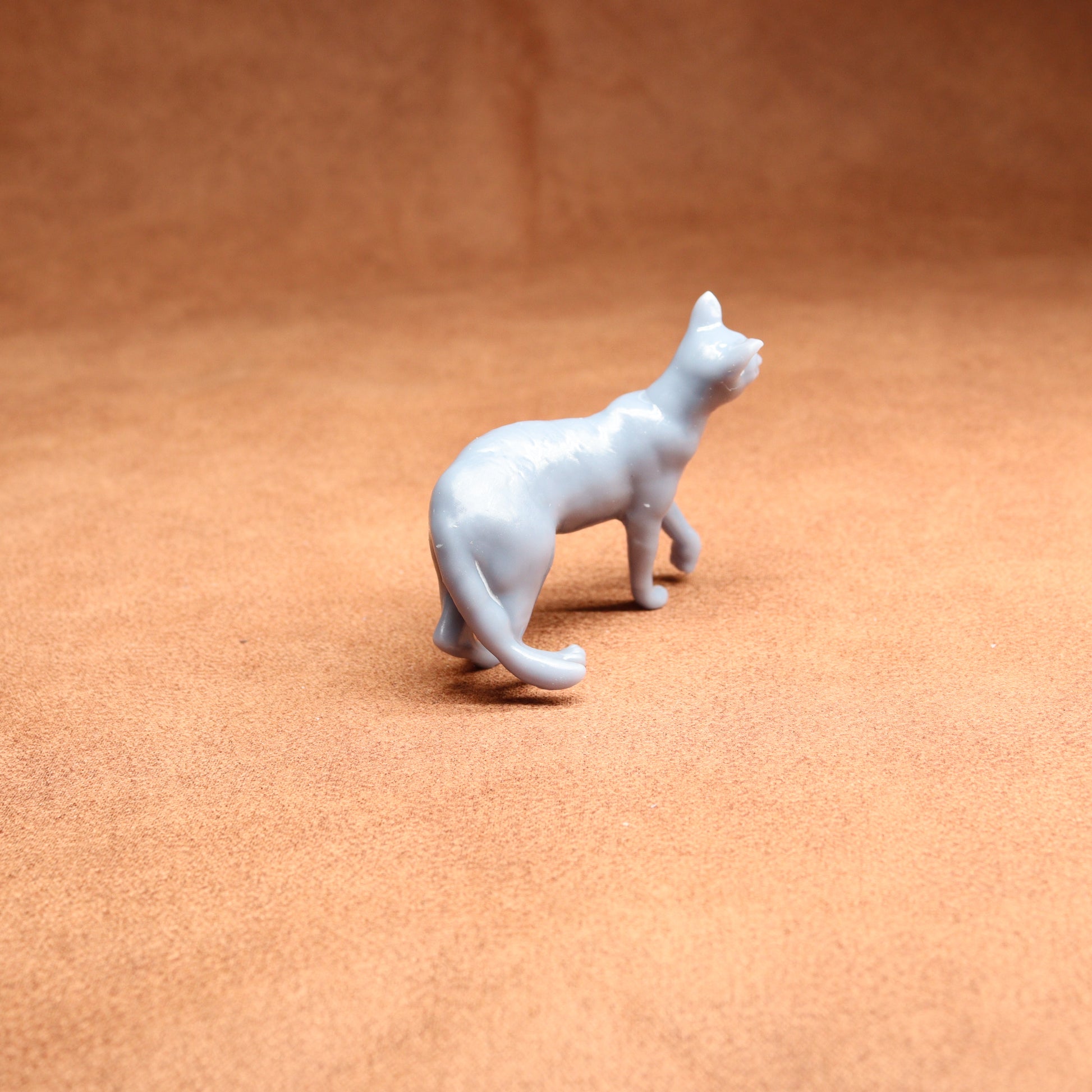 White cat figurine on a brown surface