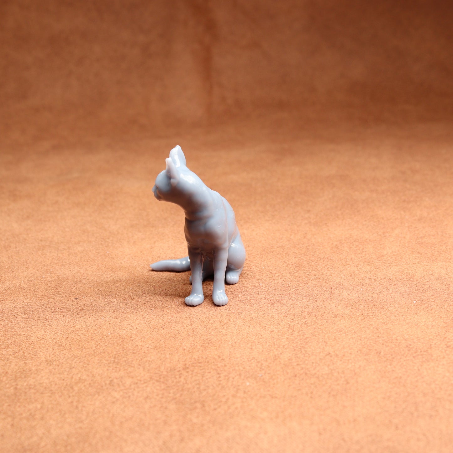 Gray cat figurine on a brown surface
