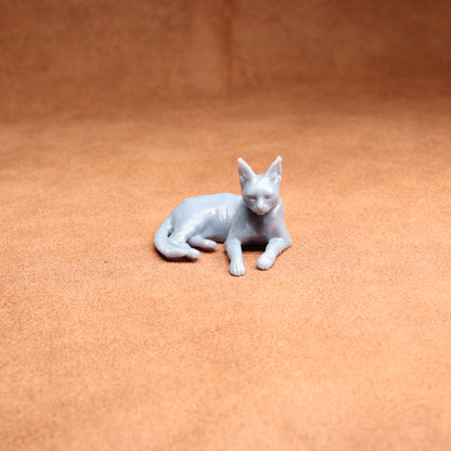 White cat figurine on a brown surface