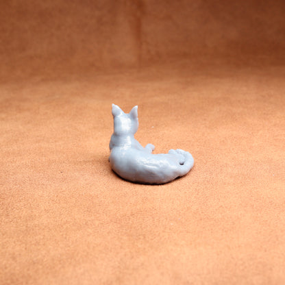 Small white ceramic fox figurine on a brown surface