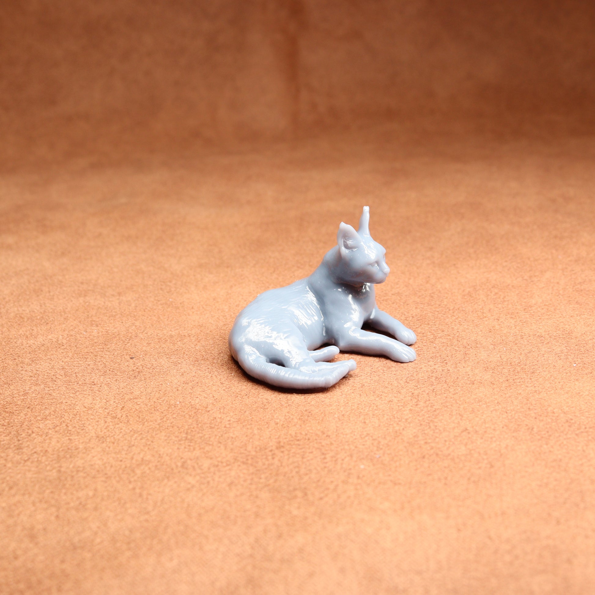 White cat figurine on a brown surface