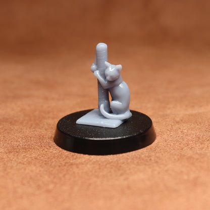 Small figurine of a cat climbing a pole on a black base against a brown background