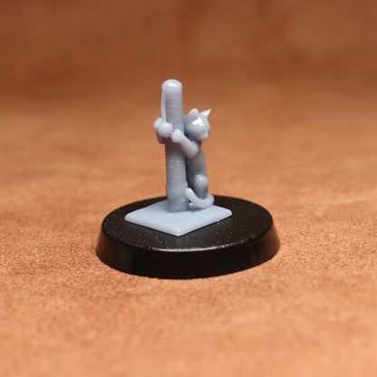 Small figurine of a cat climbing a cactus on a brown surface