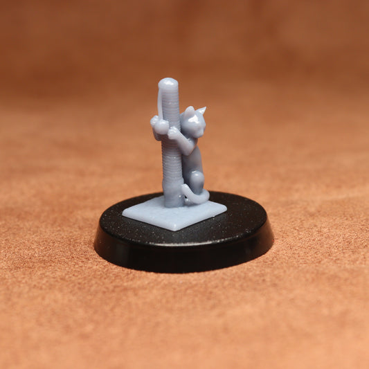 Small figurine of a cat climbing a cactus on a brown surface