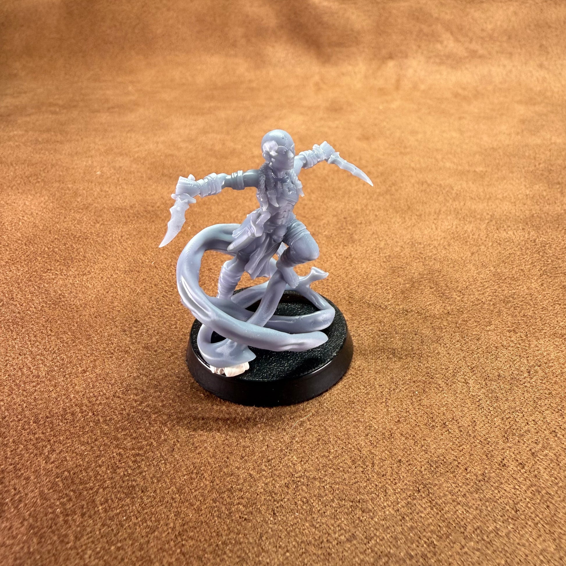 Gray figurine of a warrior with a snake on a brown surface